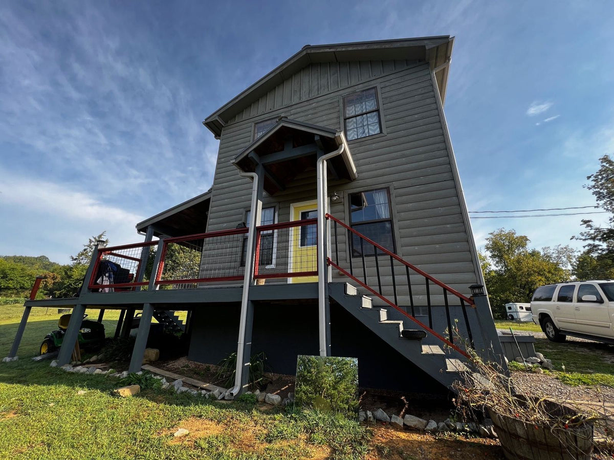 Two-story house with gray siding before conversion